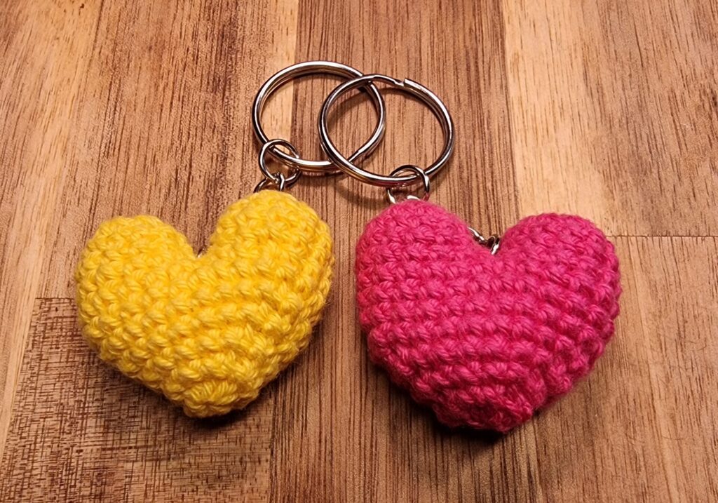 2 sleutelhangers, 1 van een geel hartje en 1 van een roos hartje